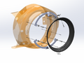 A technical cutaway rendering of a circular mechanical component, showing a translucent orange outer ring with internal gray and silver structural elements and a black circular ring in front, on a light gray background.