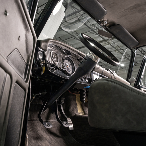 Close-up of a vintage car's interior with dashboard and 1965-66 Ford Truck Steering Column.