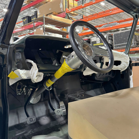 1965-66 Ford Truck Steering Column Kit   installed and dashboard of a vehicle in a warehouse setting