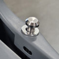 A close-up of a brushed silver metal mounting knob secured onto a gray metal frame.