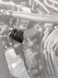 Close-up of a mechanical component with hoses and pipes in a technical setting