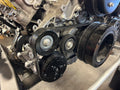 Close-up of an engine belt system with pulleys.