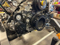 Close-up of an engine with belts and pulleys in a workshop setting