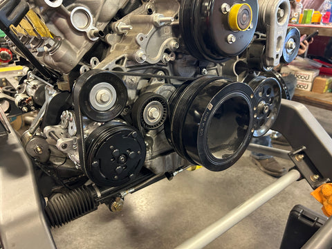 Close-up of an engine with belts and pulleys in a workshop setting
